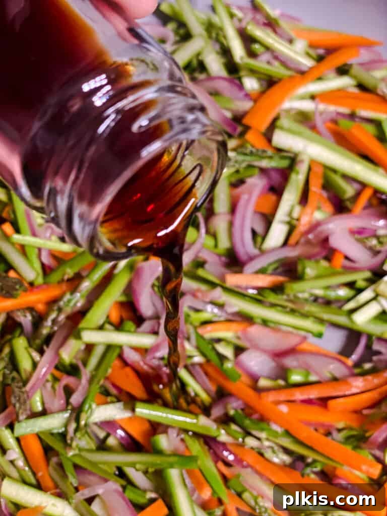 Vibrant Veggie Noodle Medley 8 process shot of adding soy sauce to pan