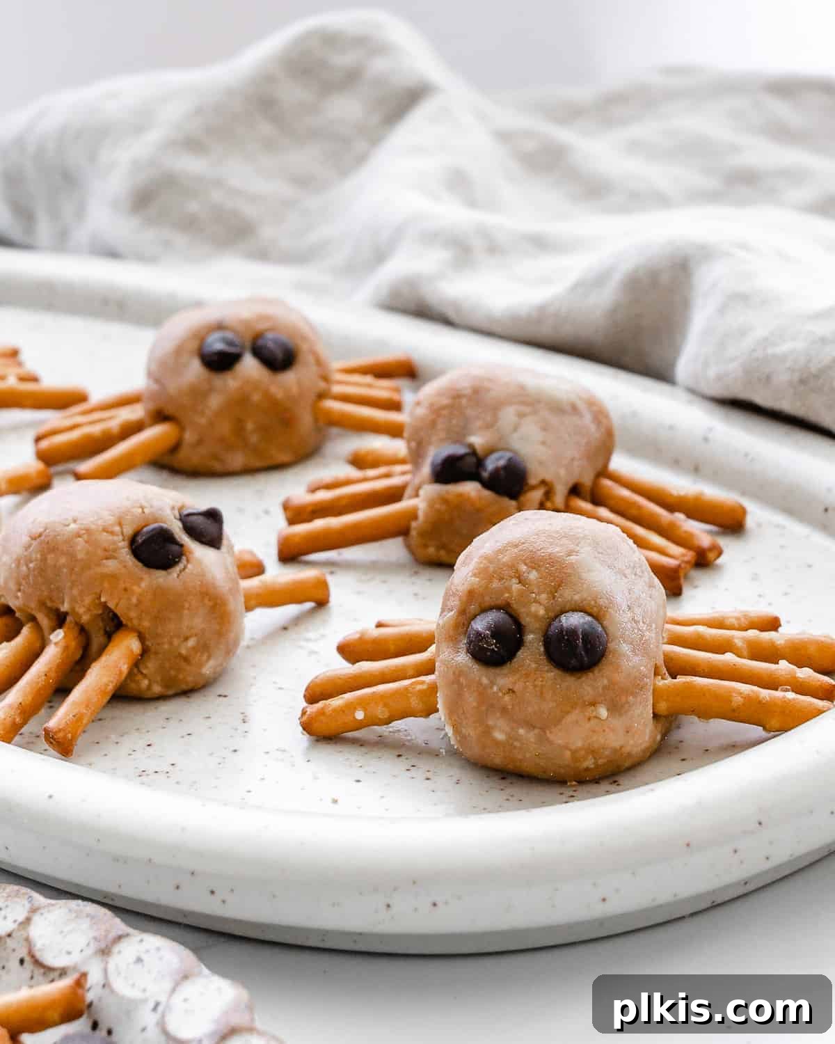 Frightfully Delicious Peanut Butter Spiders 2 Completed Halloween peanut butter spiders on a white speckled tray, ready for a party.
