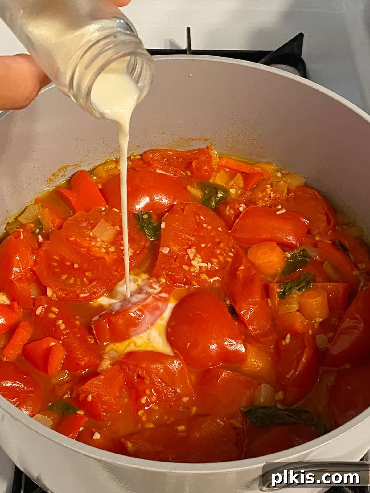 Velvety Vegan Tomato Basil Soup 12 process of adding plant based milk to pan