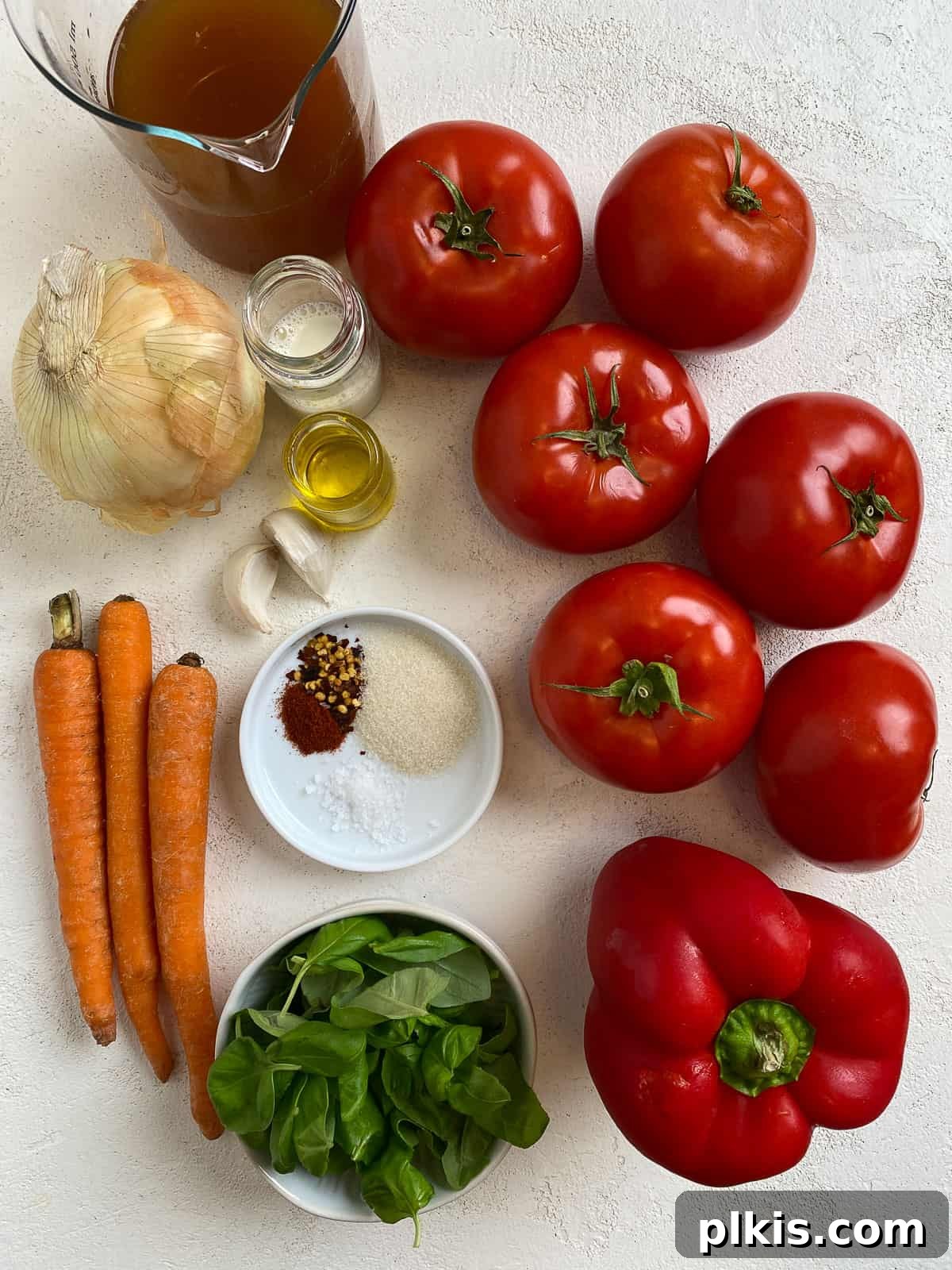 Velvety Vegan Tomato Basil Soup 3 ingredients for Tomato Basil Soup measured out against a light surface