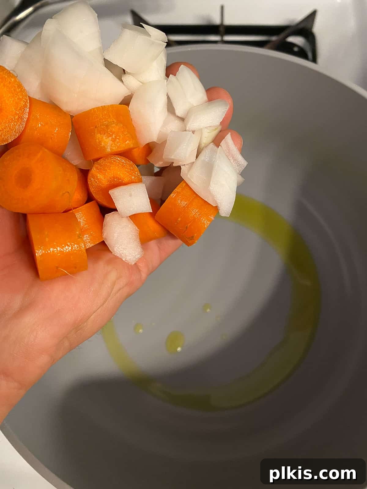Velvety Vegan Tomato Basil Soup 4 process of adding carrots and onions into a pan