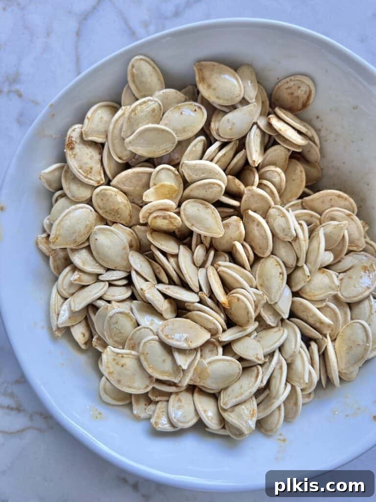 Fiery Roasted Pumpkin Seeds 5 Pumpkin seeds tossed with olive oil, soy sauce, and cayenne pepper in a mixing bowl.