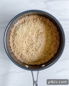 Spiced Orange Quinoa 5 A pot on the stovetop, covered with a lid, showing the Cinnamon Orange Quinoa gently simmering, indicating it's nearly cooked to perfection.