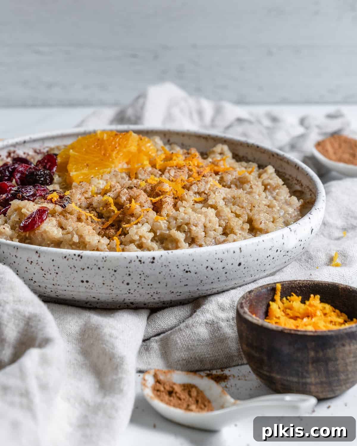 Spiced Orange Quinoa 7 A second view of the completed Cinnamon Orange Quinoa, in a bowl with a spoon, highlighting its inviting texture and vibrant orange hues against a soft background.