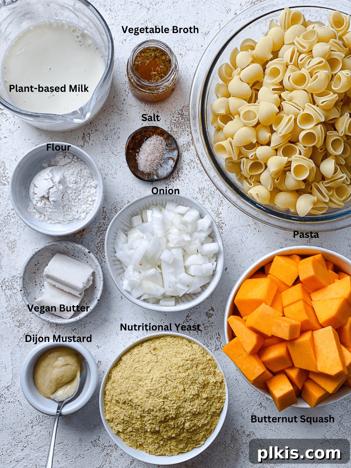 Golden Butternut Macaroni 3 Ingredients for Butternut Squash Mac and Cheese measured out on a white surface, neatly arranged.