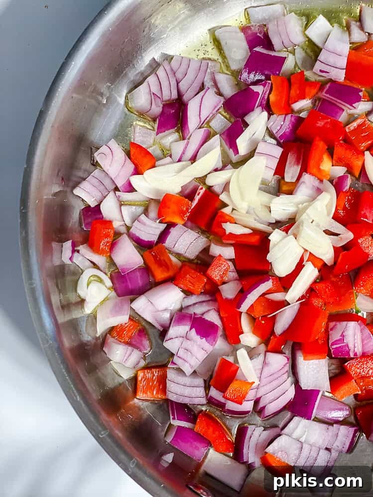 Vibrant Vegan Primavera Pasta 5 Diced onion, sliced garlic, and chopped bell pepper cooking in a large pot with oil.