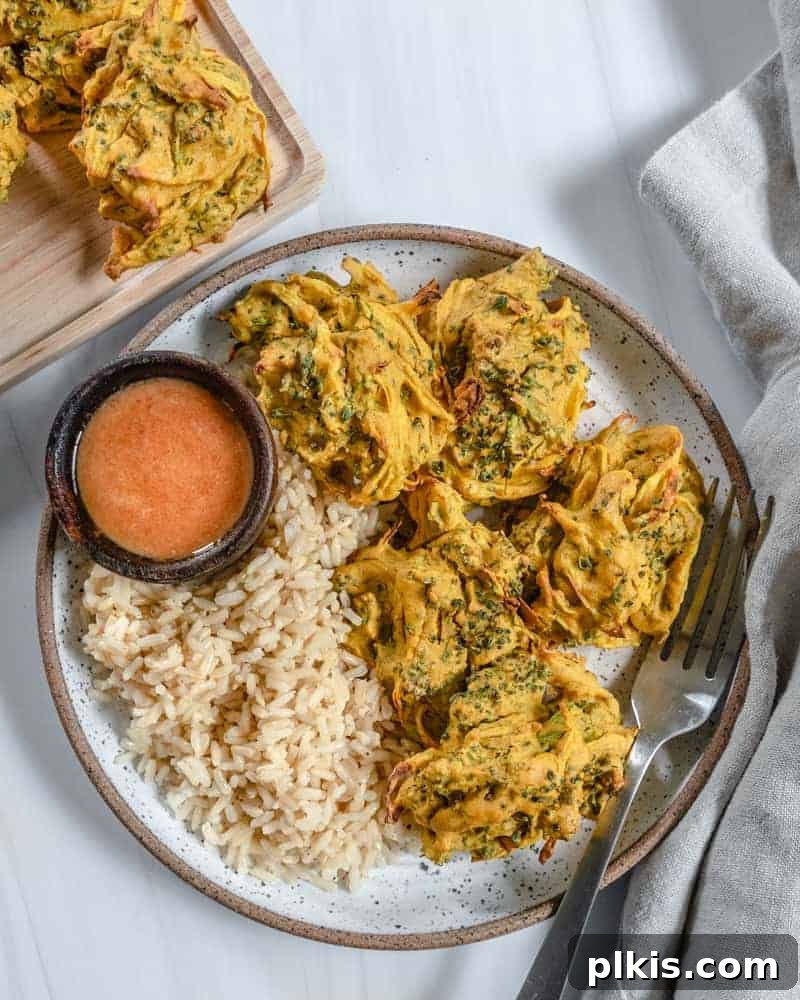 Crispy Broccoli Onion Pakora Bites 4 completed broccoli and onion pakora plated with rice and a sauce