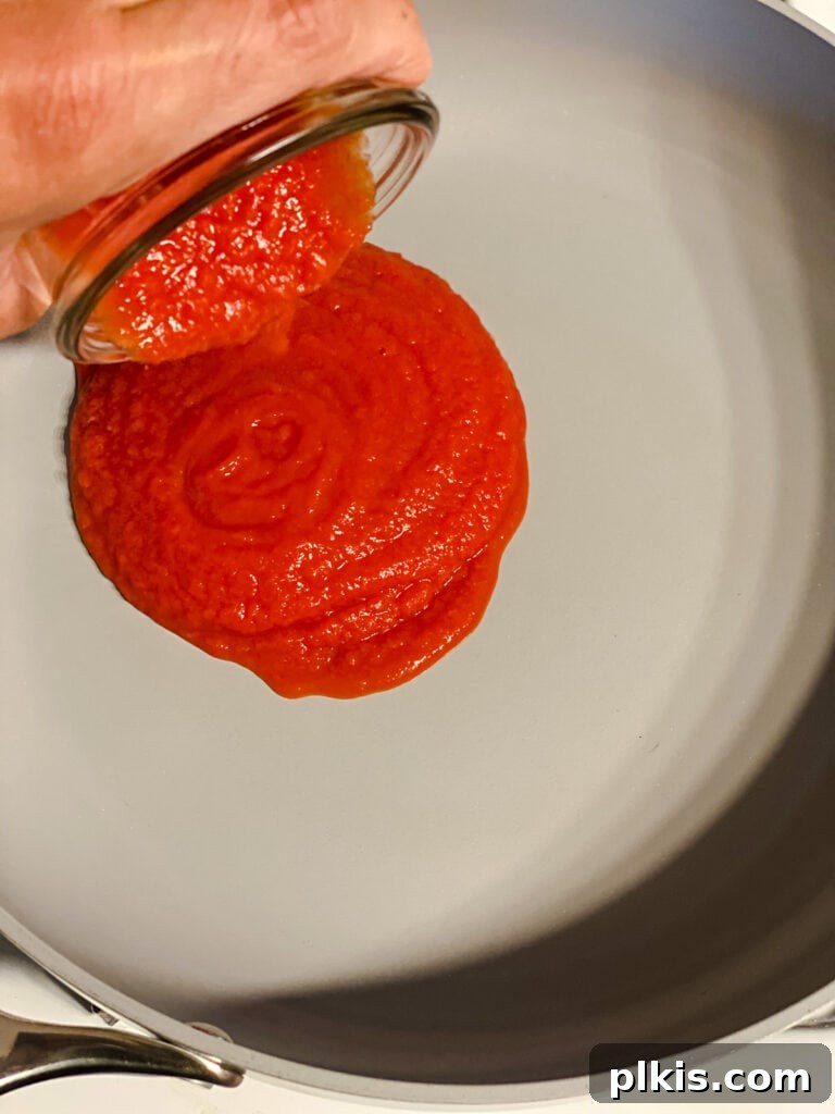Creamy Tandoori Chickpea Curry Vegan 5 process shot of adding tomato stock to pan