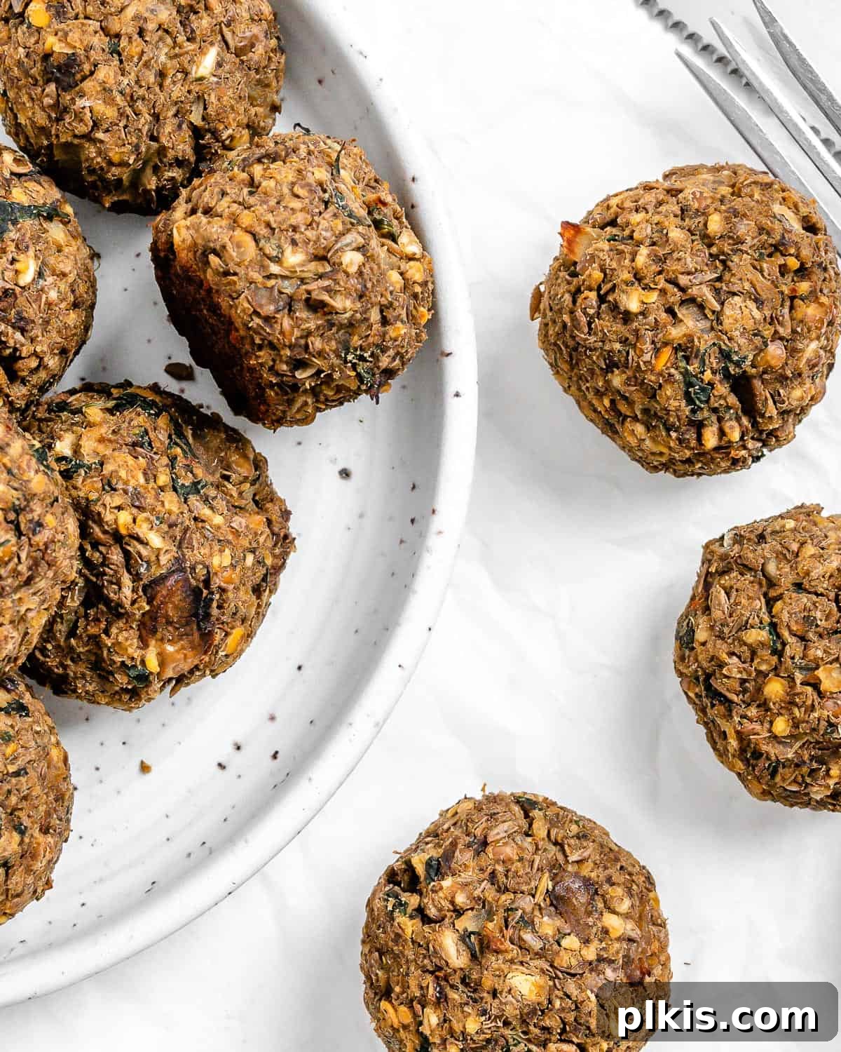 Mighty Lentil Meatballs 2 completed Vegan Lentil Meatballs plated and scattered on a white surface