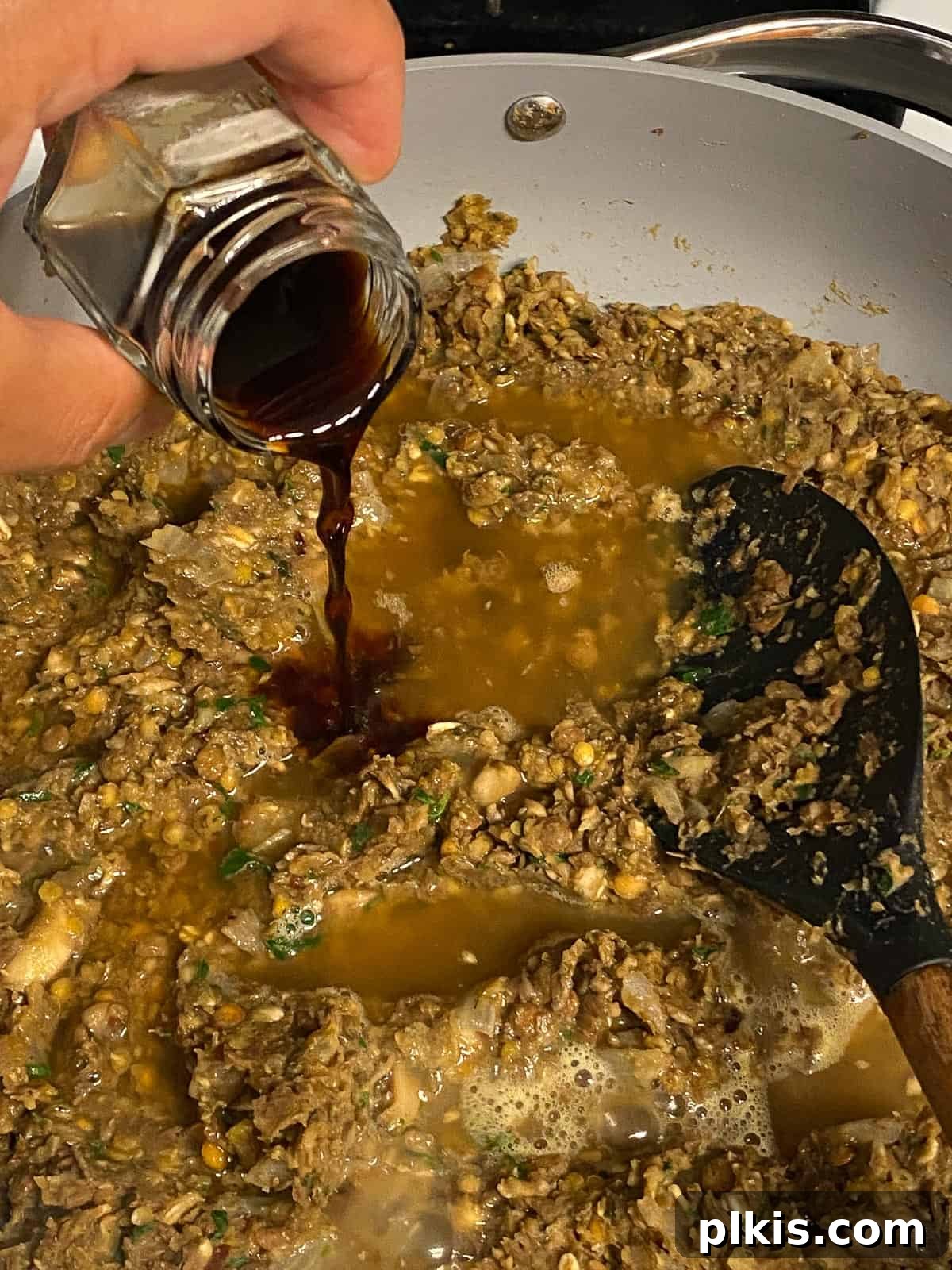 Mighty Lentil Meatballs 13 process shot of adding soy sauce to pan