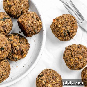 Mighty Lentil Meatballs 18 completed Vegan Lentil Meatballs plated and scattered on a white surface