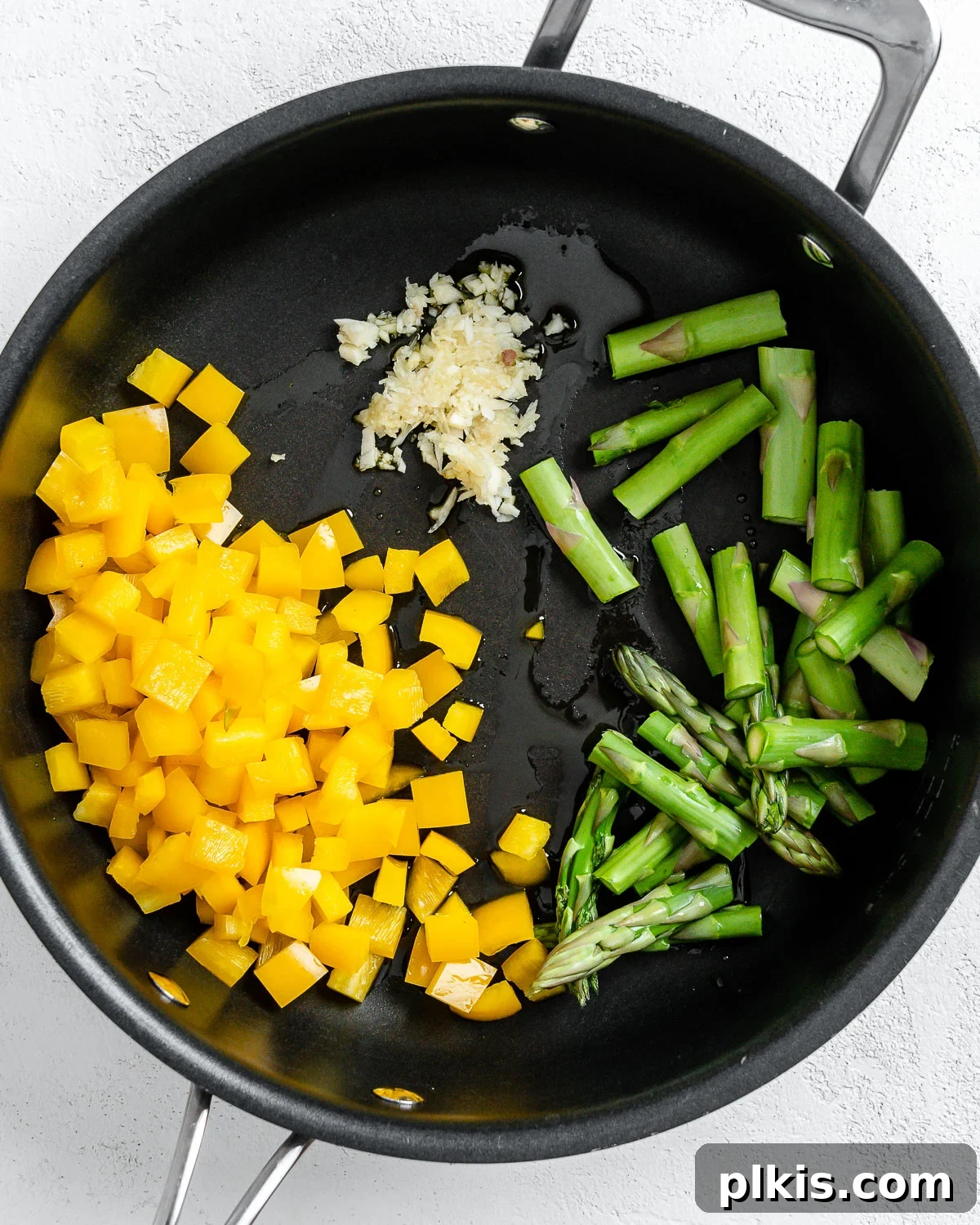 Vibrant Vegan Couscous with Fresh Vegetables 5 The addition of vibrant veggies and aromatic spices into a black pan, showing the sautéing process
