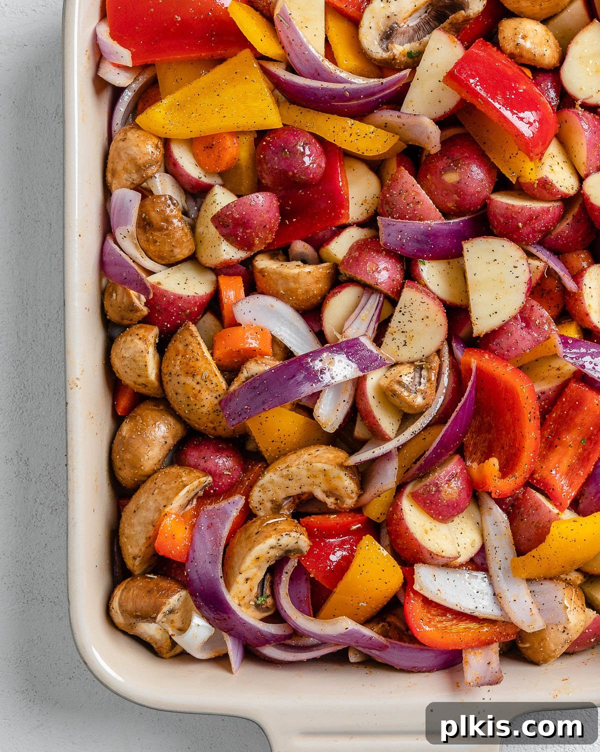 Thyme Kissed Roasted Vegan Medley 11 Pre-cooked Vegan Roasted Vegetables with Thyme spread evenly in a 9x13-inch baking dish, ready for the oven.