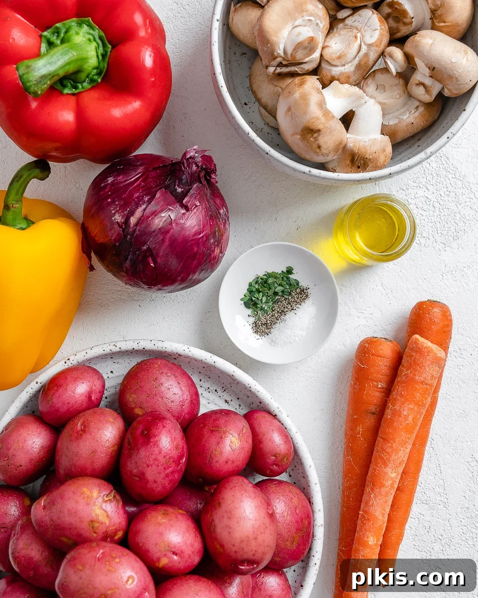 Thyme Kissed Roasted Vegan Medley 3 Ingredients for Vegan Roasted Vegetables with Thyme spread out on a white surface, including potatoes, onions, carrots, mushrooms, and bell peppers, along with oil and dried thyme.