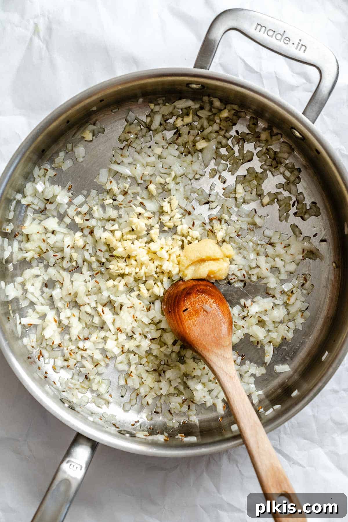 Spiced Potato & Pea Curry Made Simple 5 Process shot showing stirring ingredients in pan.