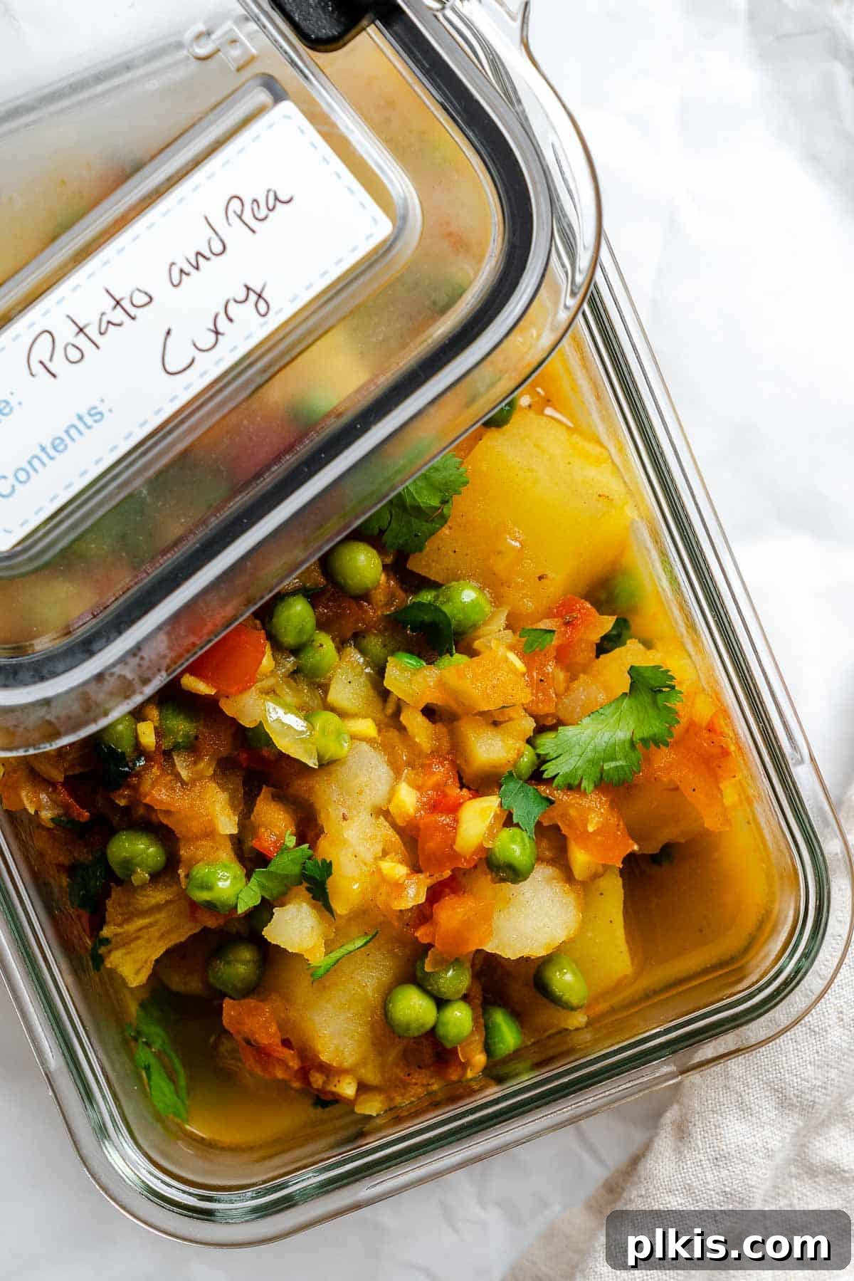Spiced Potato & Pea Curry Made Simple 10 Completed Easy Potato and Pea Curry (Aloo Matar) in a storage container.