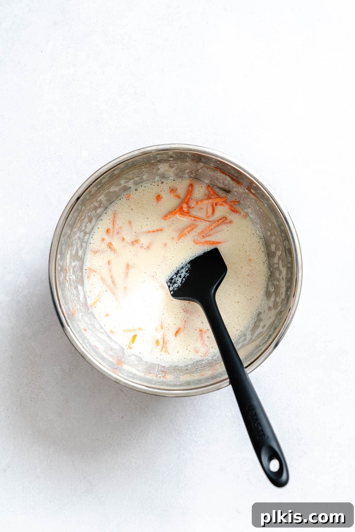 Spiced Carrot Cake Pancakes 5 Process shot showing adding shredded carrots to the wet mix.