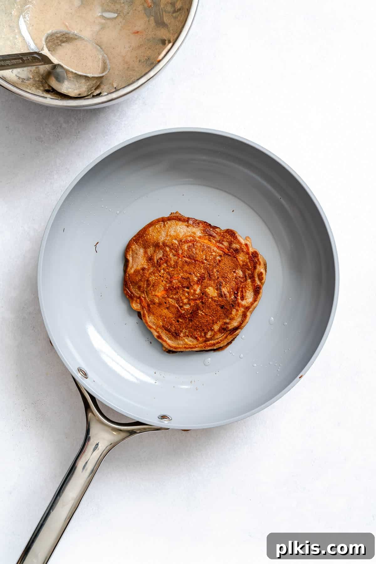 Spiced Carrot Cake Pancakes 7 Process shot showing pancake cooking on pan.