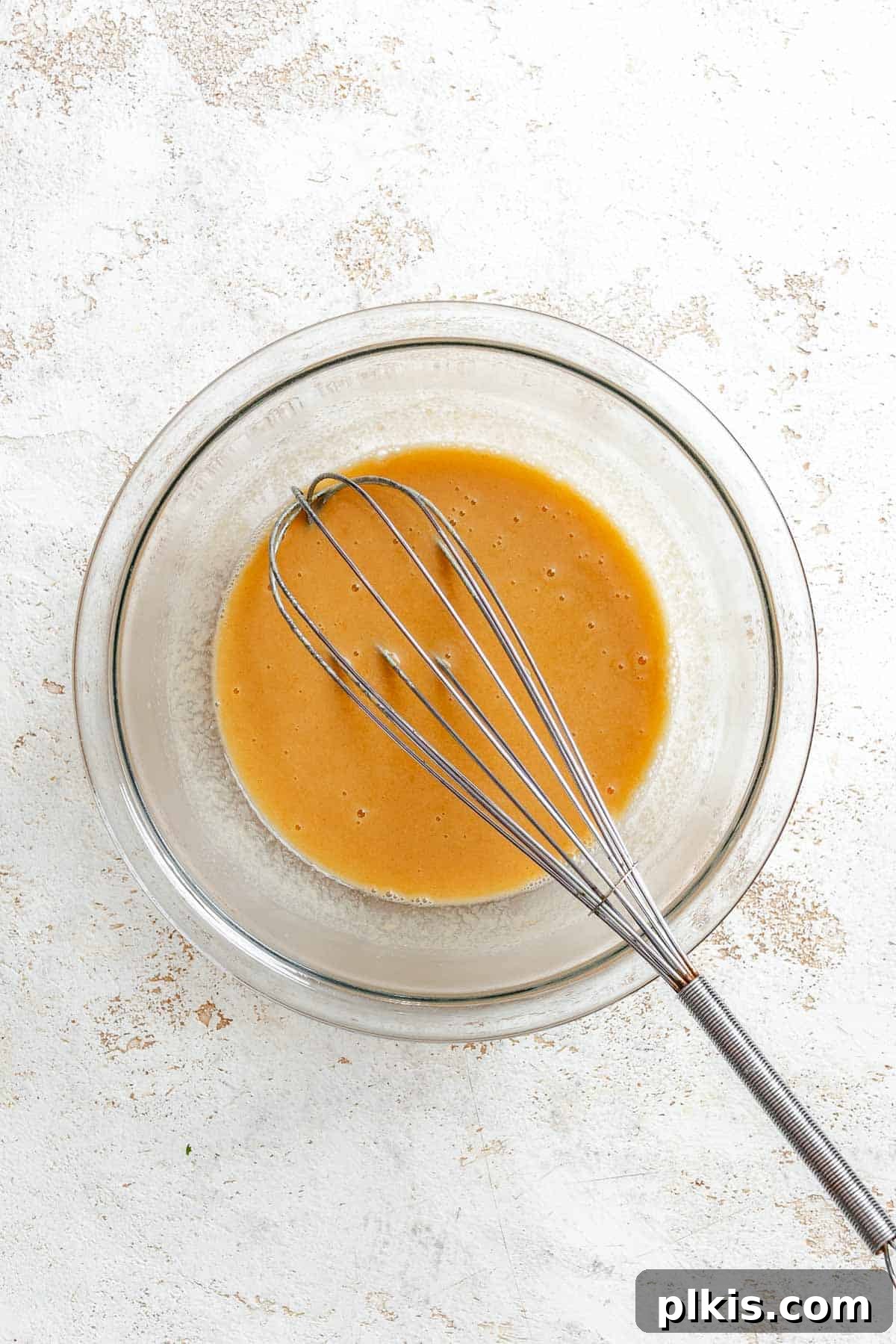 Rich Vegan Peanut Butter Bliss 4 Process shot showing whisking ingredients in a bowl for vegan peanut butter cake batter.