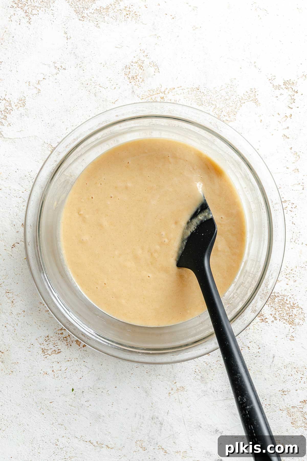 Rich Vegan Peanut Butter Bliss 6 Process shot showing mixing applesauce and plant-based milk into cake batter.
