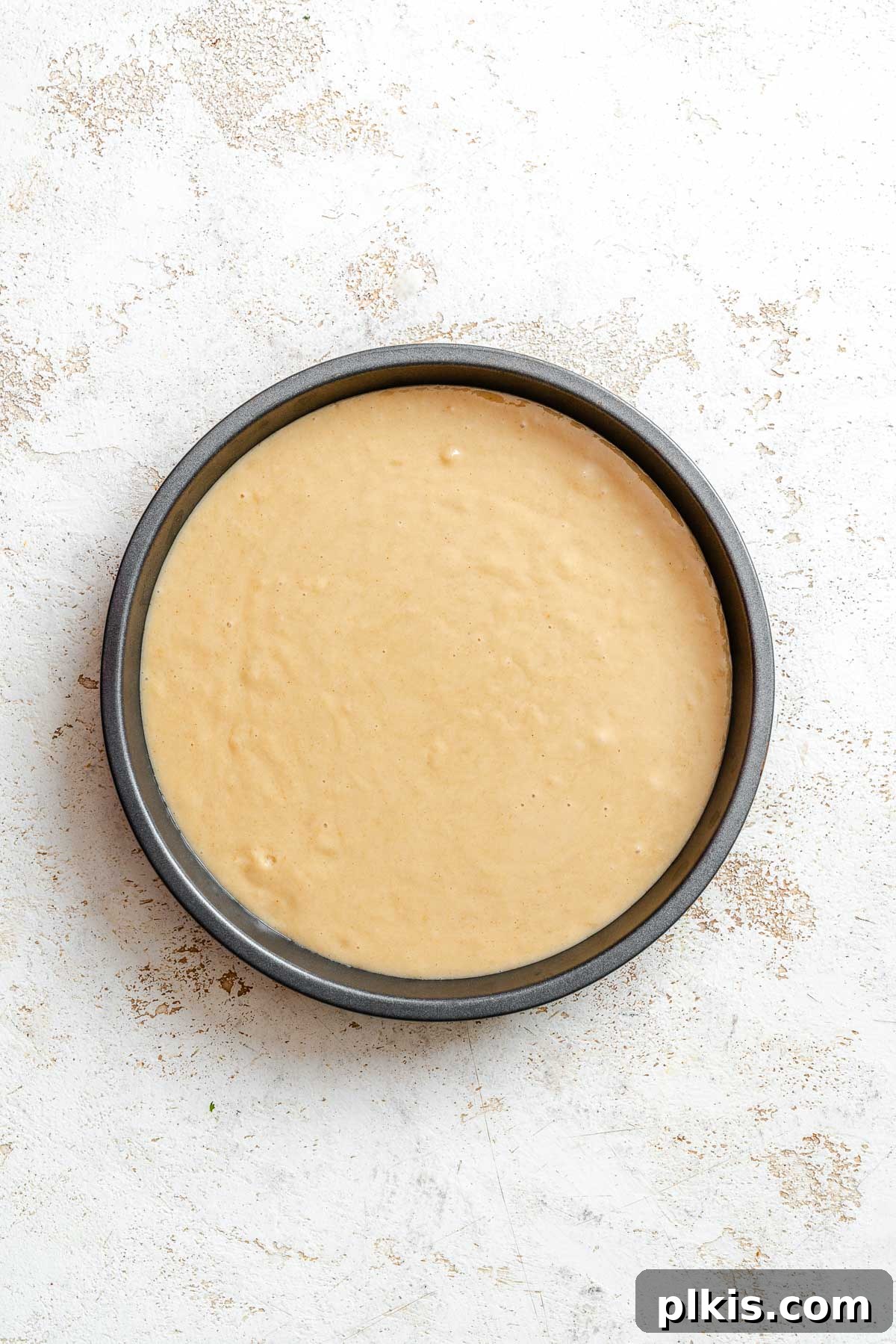 Rich Vegan Peanut Butter Bliss 7 Process shot showing cake batter added evenly to a round cake pan.