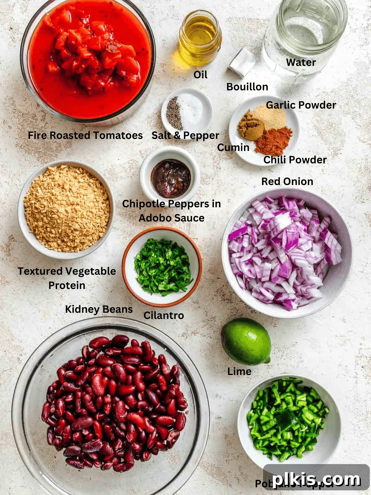Smoky Chipotle Chili 3 Ingredients for Chipotle Chili Recipe measured out on a white surface, including canned goods, fresh vegetables, and spices.