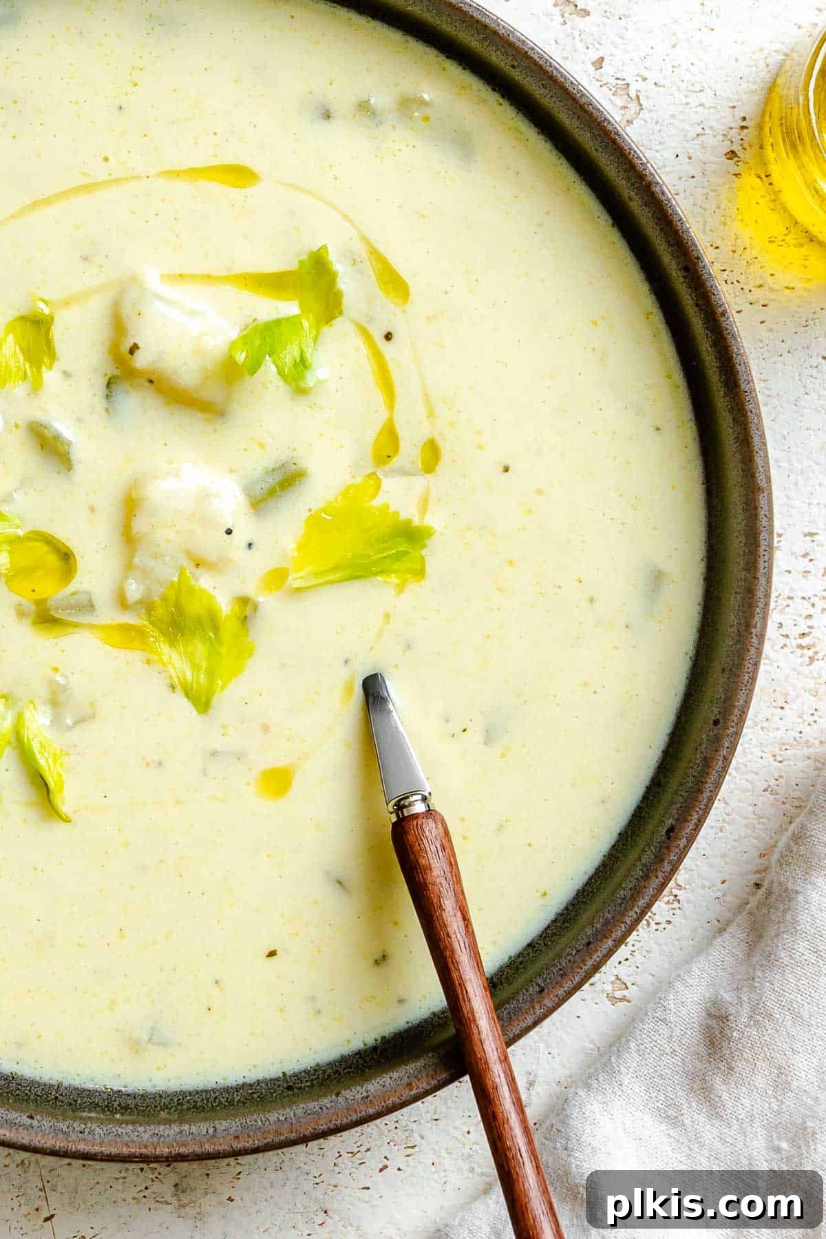 Velvety Celery Soup 2 Completed Cream of Celery Soup in a bowl, garnished with fresh herbs.