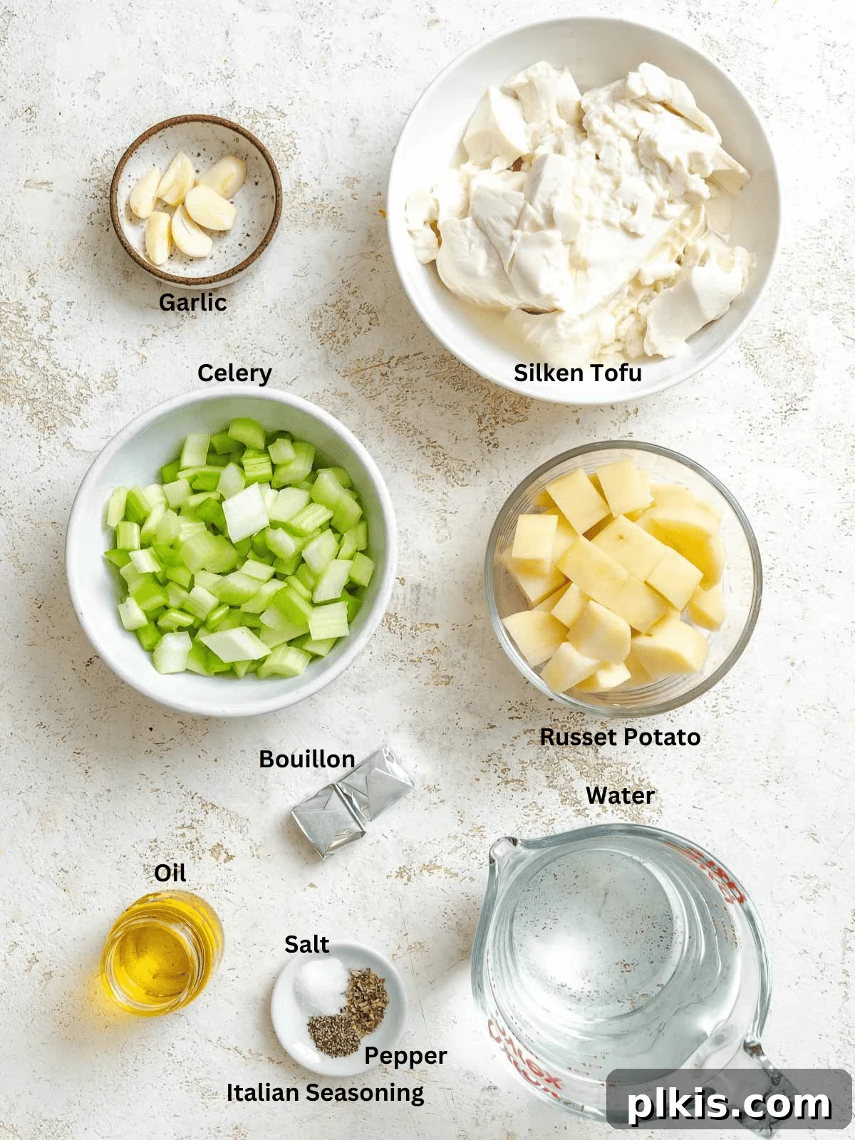 Velvety Celery Soup 3 Ingredients for Cream of Celery Soup measured out on a white surface, including celery, potatoes, garlic, and seasonings.
