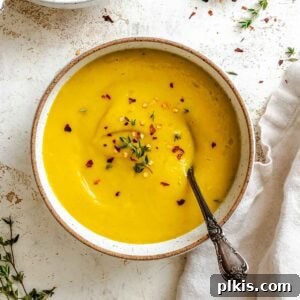 Velvety Golden Kabocha Soup 11 Completed Kabocha Squash Soup in two bowls on a white surface.