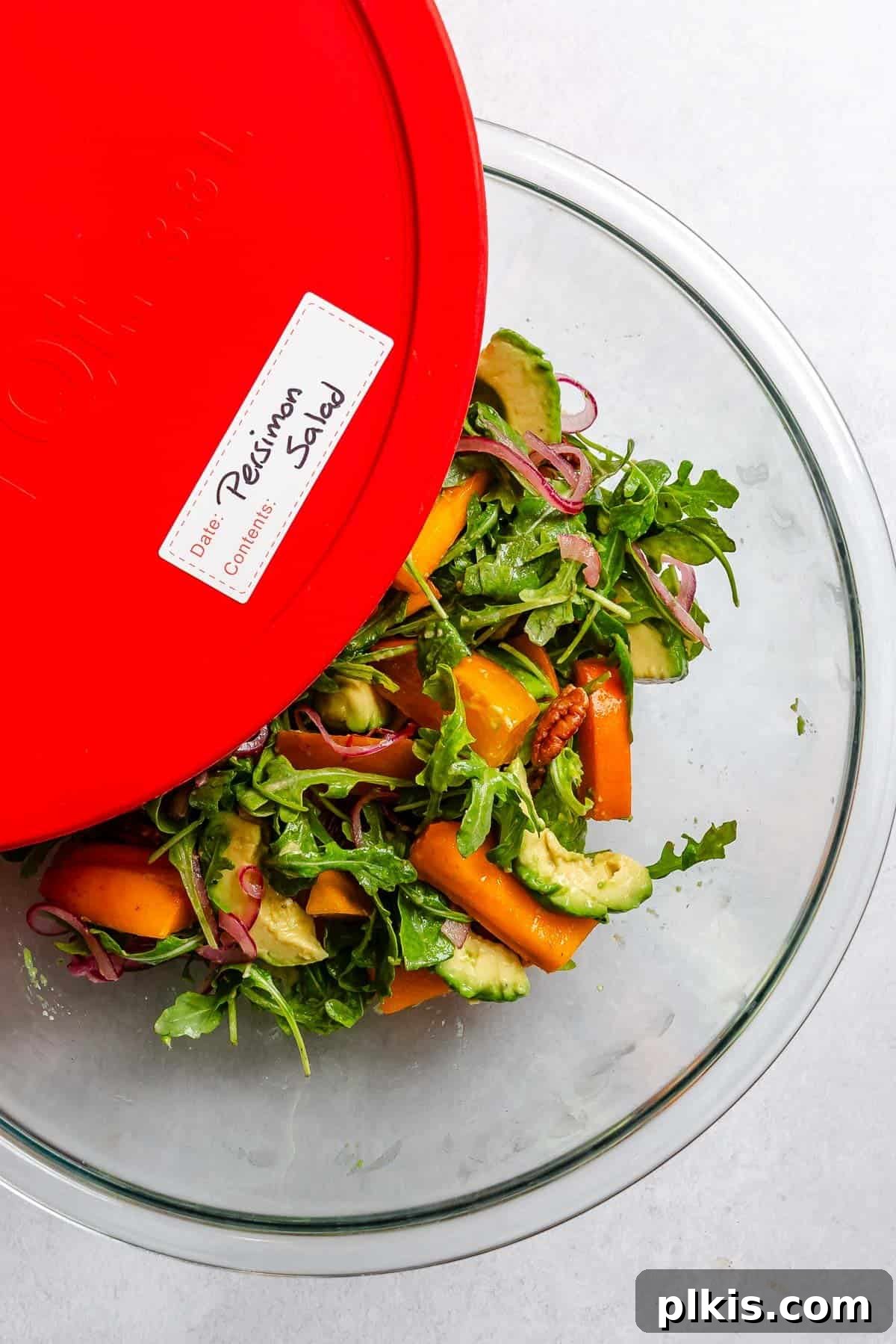 Golden Harvest Persimmon Salad 9 Completed Persimmon Salad in a storage container. A meal prep container with salad components.