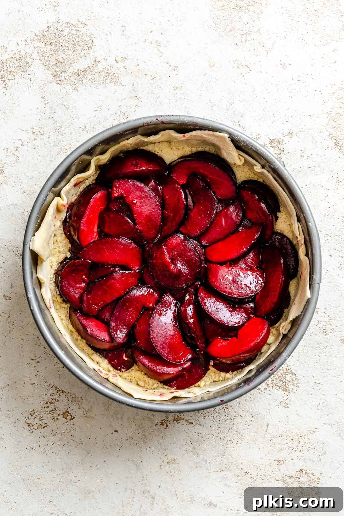 Classic Plum Galette Recipe: Homemade Rustic Tart with Fresh Plums 8 Process shot showing plum mixture added to pan.