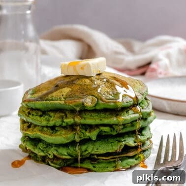 Crispy Vegan Banana Waffles with Maple Syrup Recipe 12 completed stack of Easy Banana Spinach Pancakes against a light surface