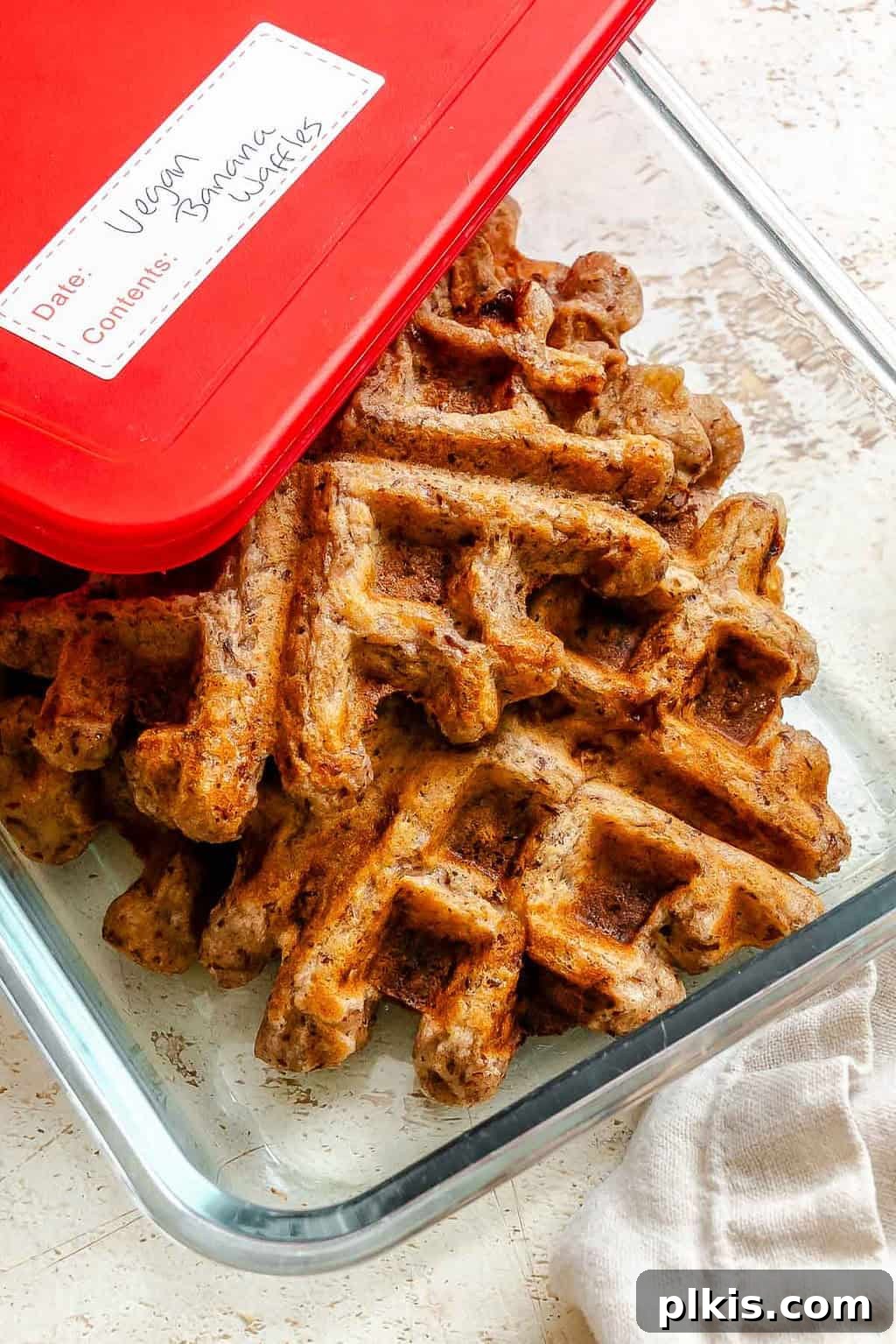 Crispy Vegan Banana Waffles with Maple Syrup Recipe 9 Completed Vegan Banana Waffles in a storage container.