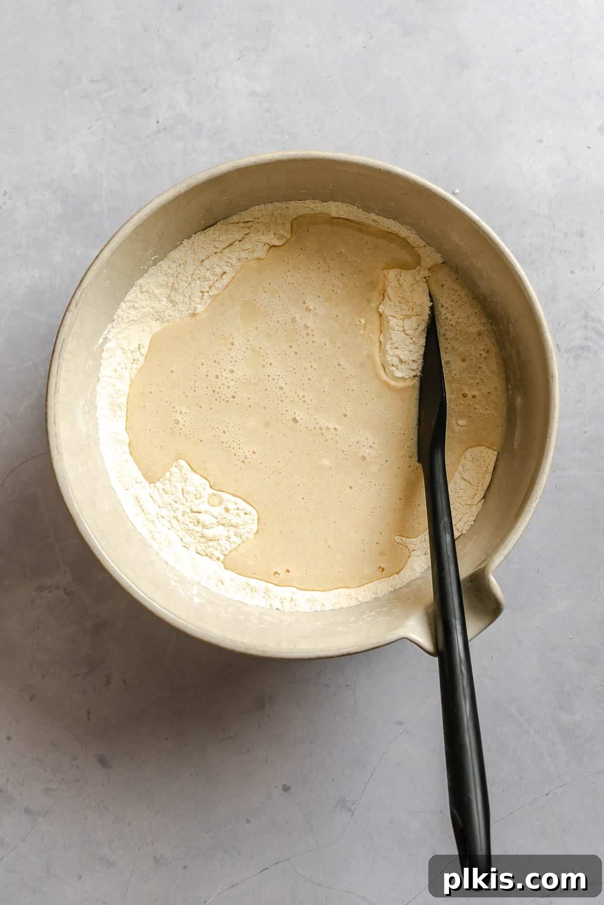 Egg-Free Grape Muffins Recipe 5 Process shot showing mixing ingredients in a bowl.
