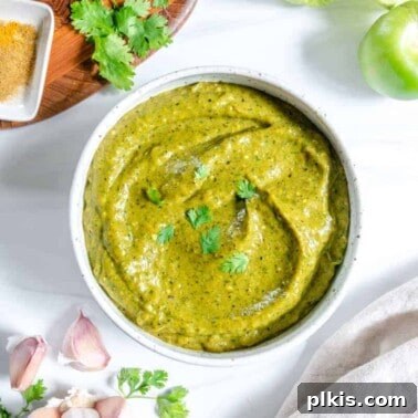 Fresh Strawberry Salsa: Sweet, Tangy Summer Recipe 11 completed Creamy Tomatillo Avocado Salsa Verde in a white bowl against a white background with ingredients in the background