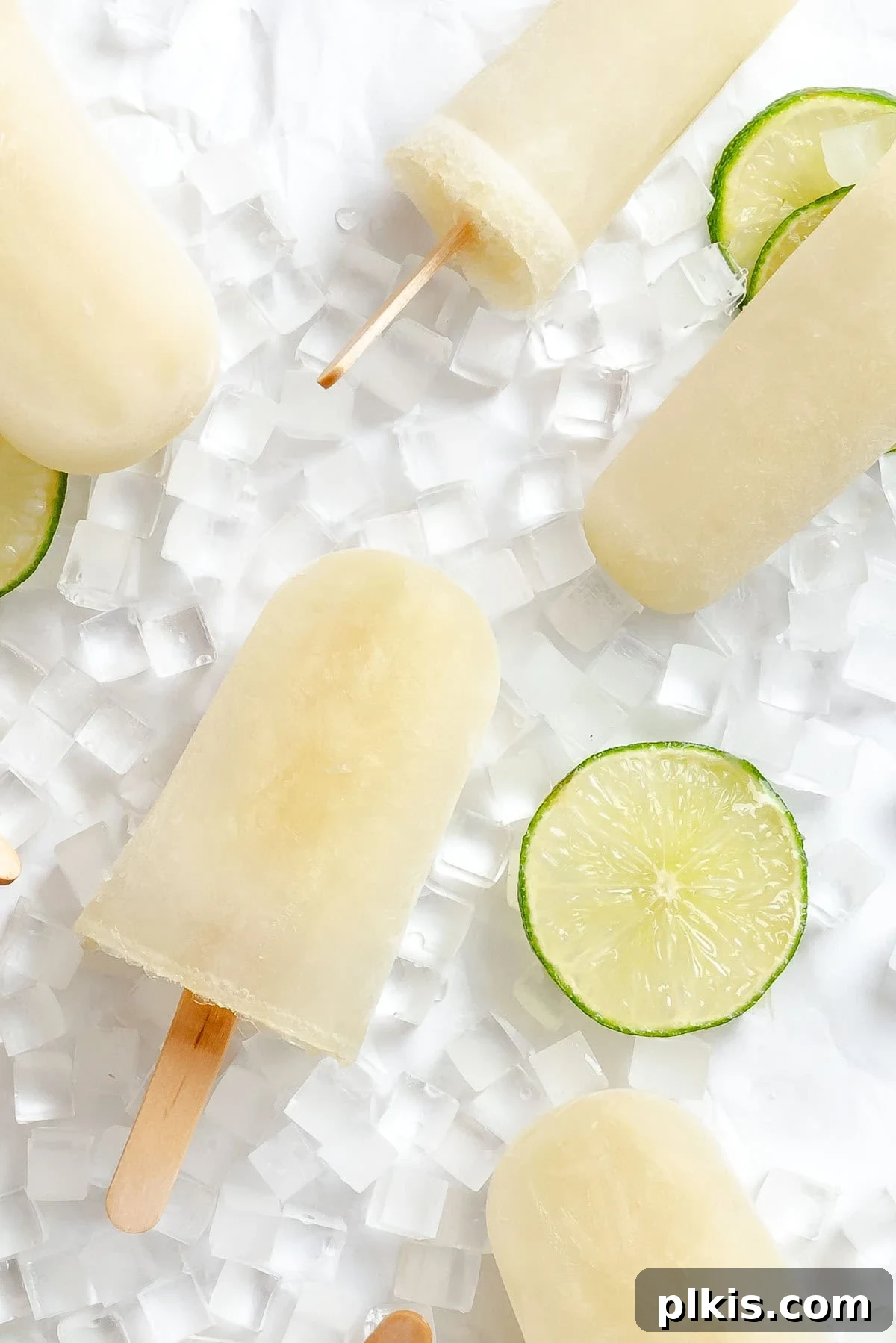 Homemade Zesty Lime Popsicles Recipe 2 Several completed Easy Lime Popsicles on a white surface.