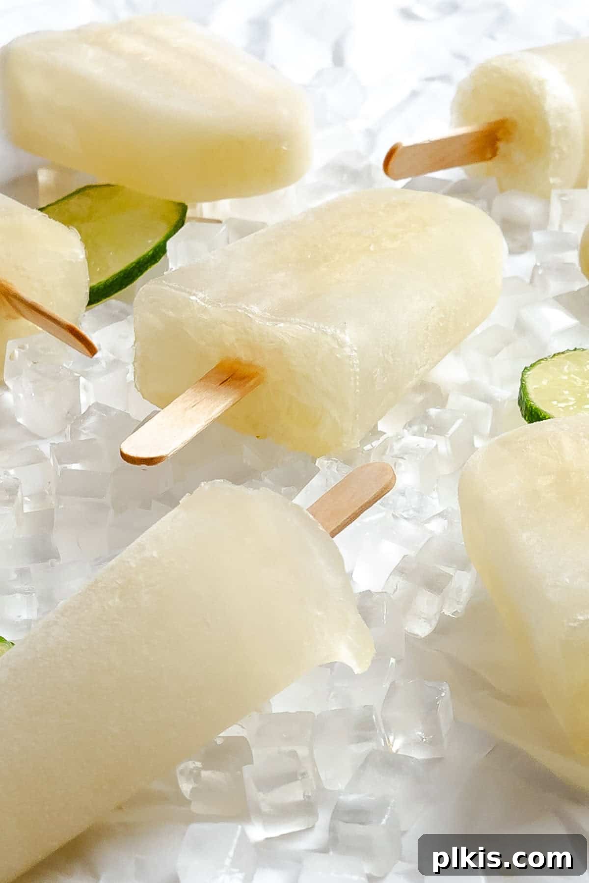 Homemade Zesty Lime Popsicles Recipe 7 Several completed Easy Lime Popsicles on a white surface.