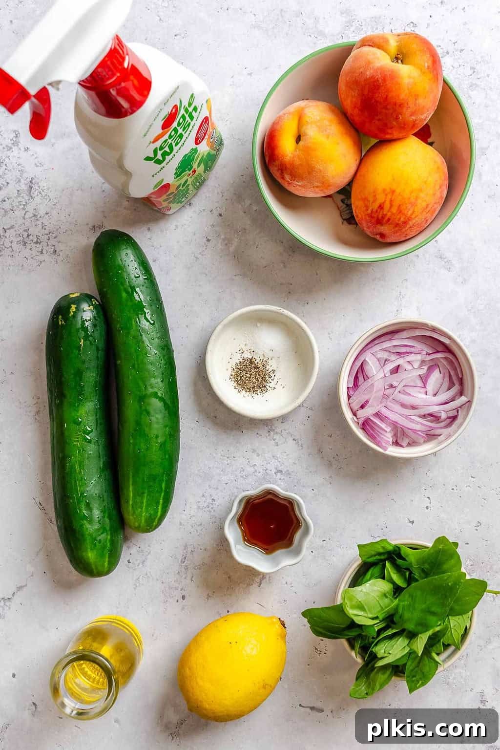Cucumber and Peach Salad with Mint Lemon Vinaigrette 4 Ingredients for Cucumber Peach Salad measured out on a white surface.