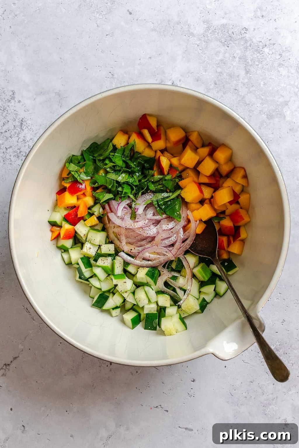 Cucumber and Peach Salad with Mint Lemon Vinaigrette 6 Process shot showing ingredients in a bowl.