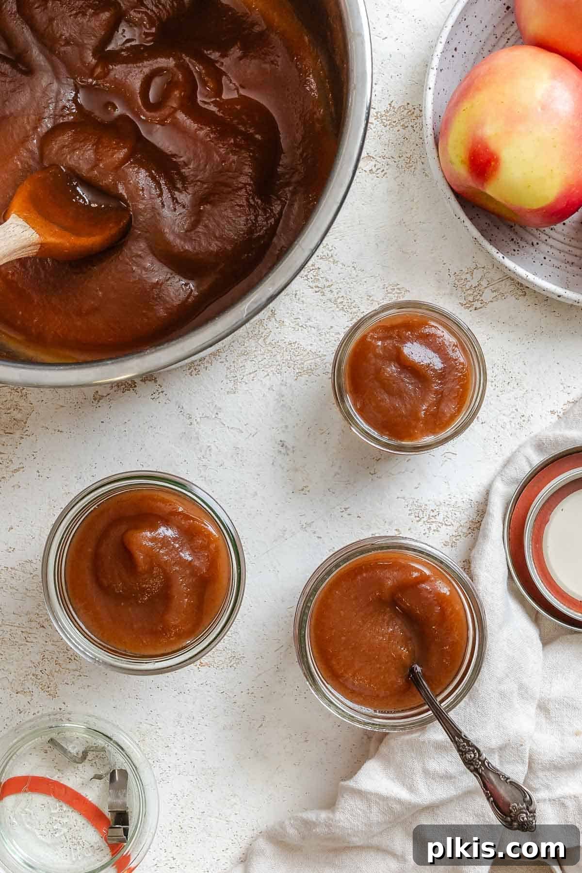 Process shot showing added apple butter to individual jars.