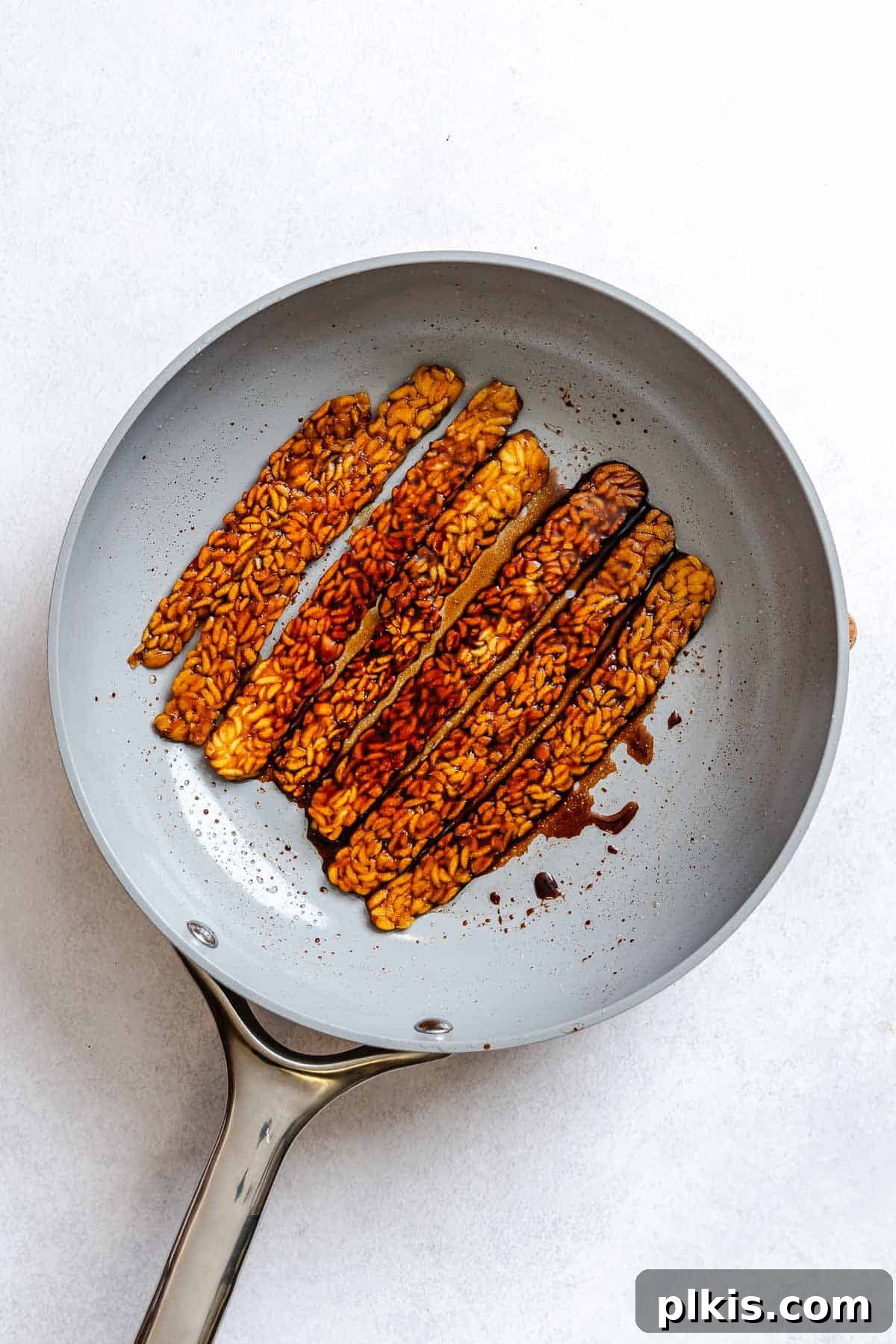 Cooking tempeh bacon in a pan.