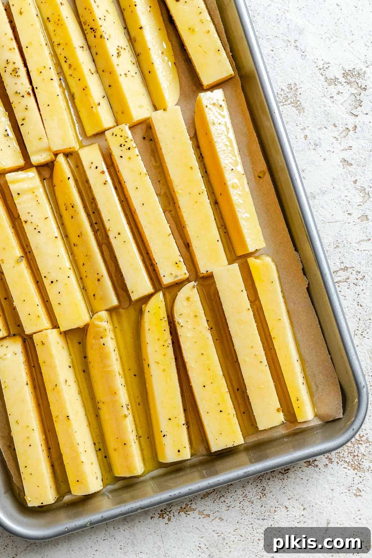 Process shot showing polenta fries added to baking tray.