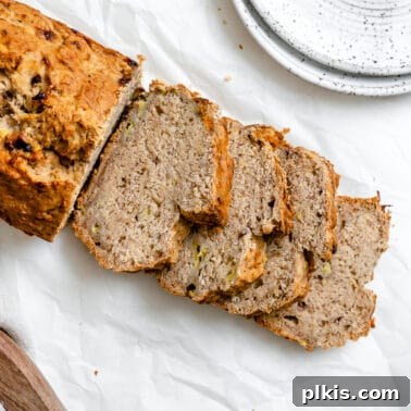Eggless Cranberry Orange Bread Recipe 13 completed sliced Easy Vegan Banana Bread (With Applesauce) in a loaf pan against a white background