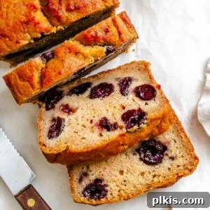 Eggless Cranberry Orange Bread Recipe 15 Completed Cranberry Orange Bread (Eggless!) sliced on white surface.