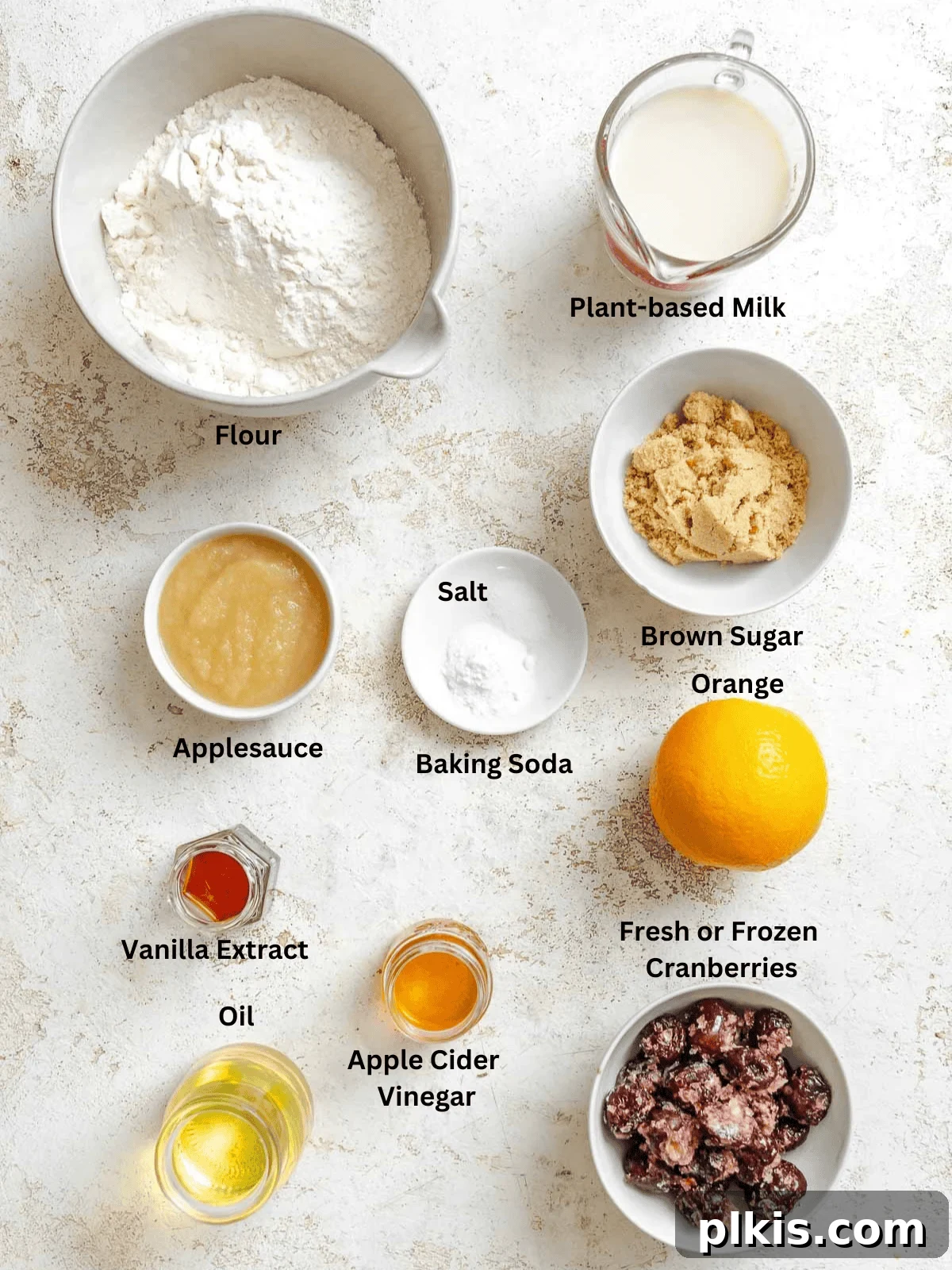 Eggless Cranberry Orange Bread Recipe 3 Ingredients for Cranberry Orange Bread (Eggless!) measured out on a white surface.