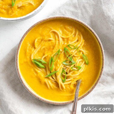 completed Curried Carrot Soup with Noodles against a white surface