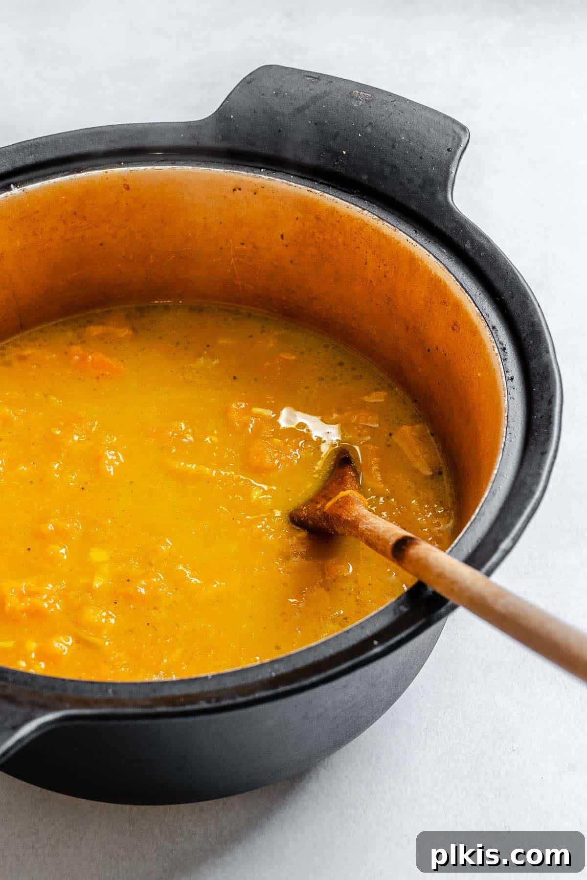 Creamy Curried Butternut Squash Soup 7 Process shot showing stirring ingredients in a pot.